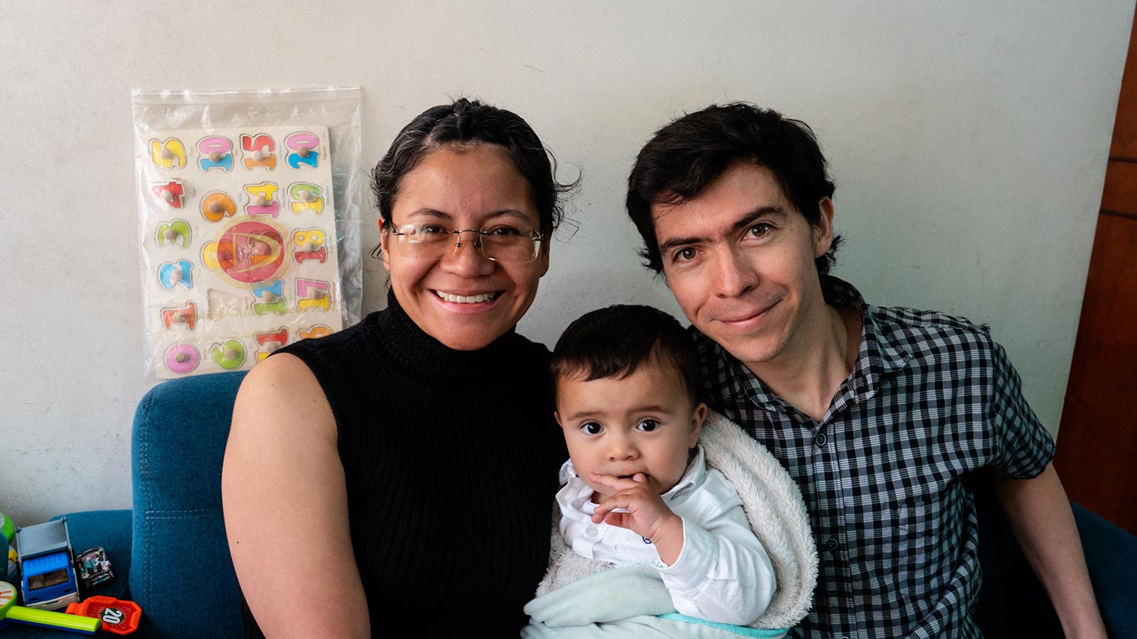 two parents smile and hold their infant son in colombia