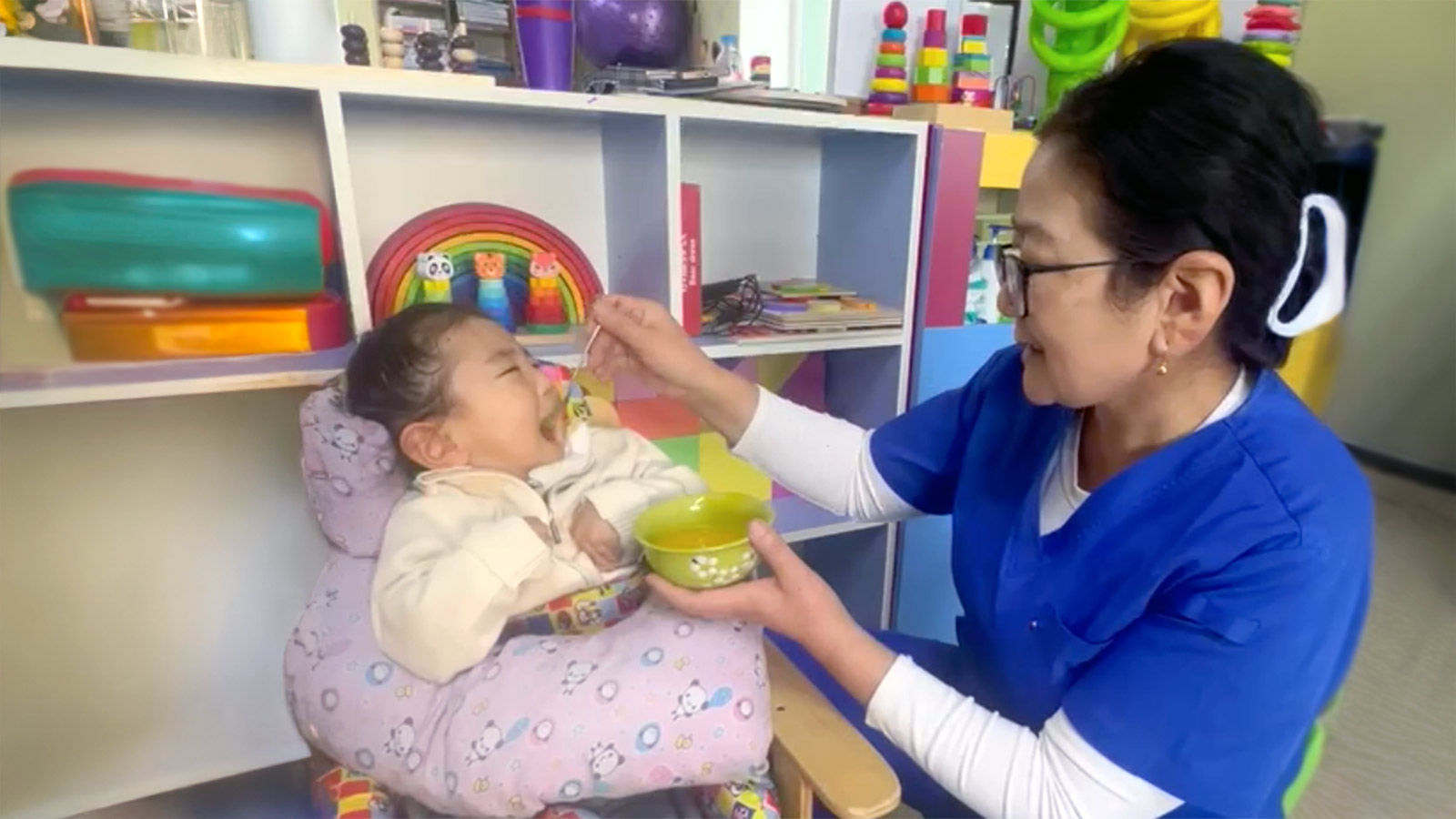 a caregiver feeds a boy in Mongolia