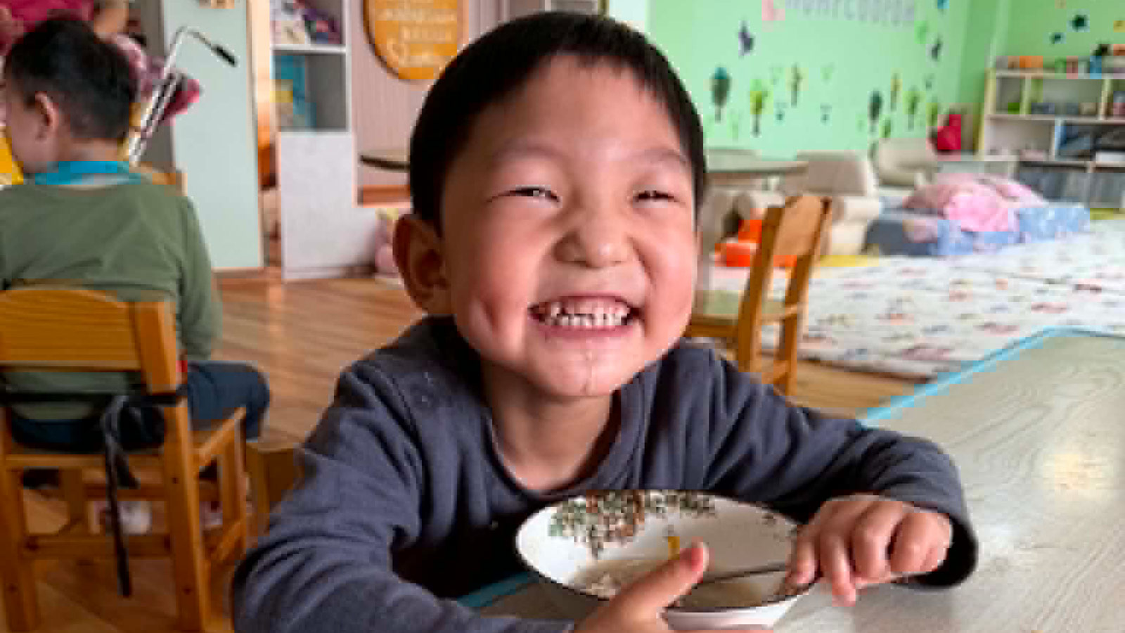 A boy at a special needs kindergarten in Mongolia enjoys a meal