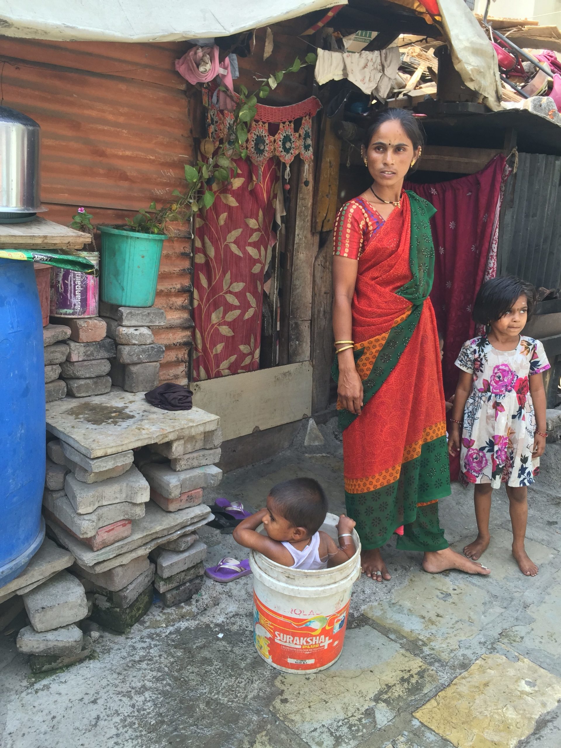 Raji's neighbor bathes her son in a bucket outside their home.