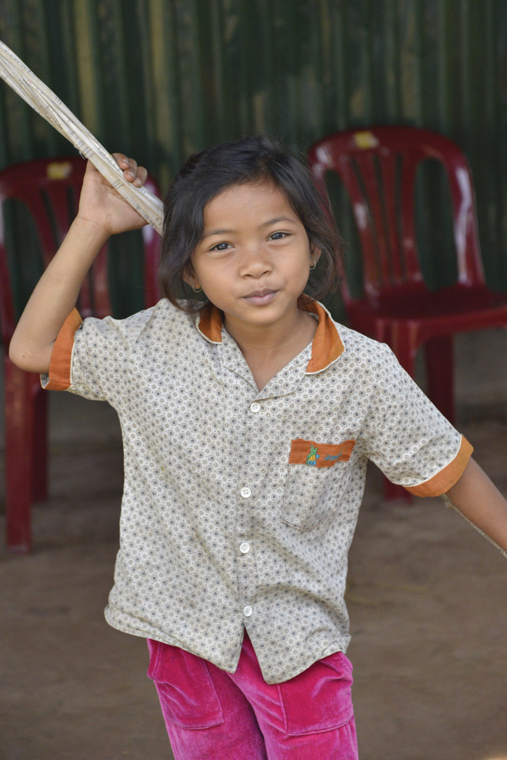 Photo of a child smiling and thanking sponsors. Cambodia sponsorship helps provide her with an education.
