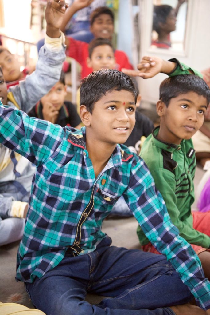 9-yearold Arjun raising his hand to tell his classmates that he wants to be an engineer someday.