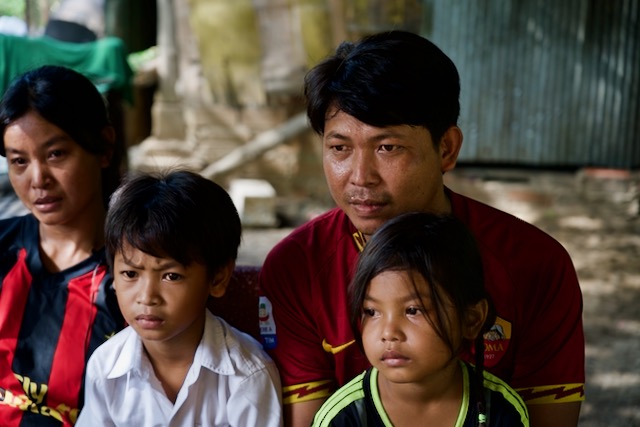 Thak Kan, center, sits with his parents and younger sister.