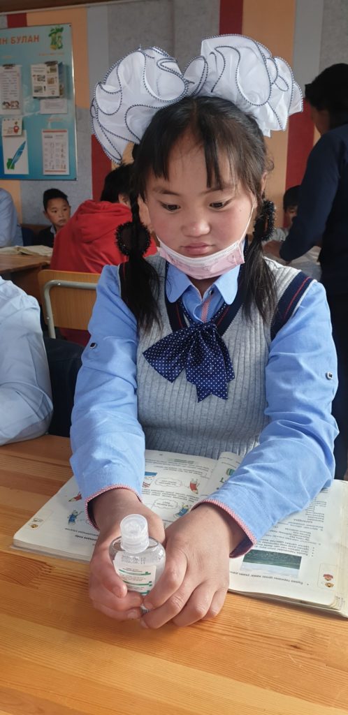 student with hand sanitizer