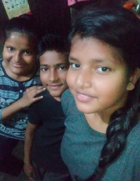 girl and siblings looking into camera