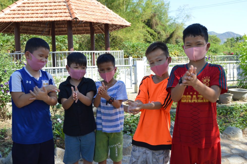 five boys in light pink masks