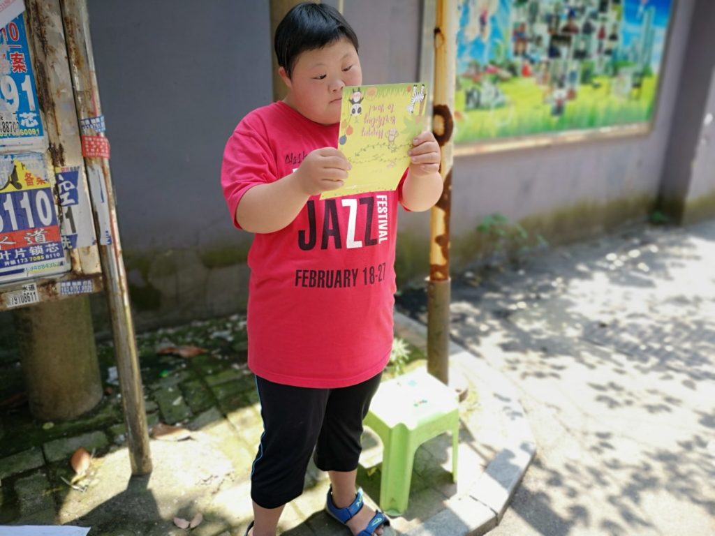 boy in red shirt reading birthday card