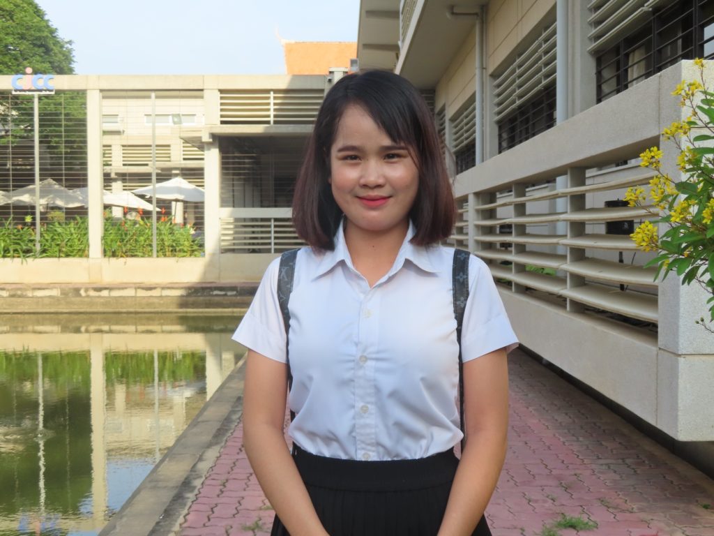 girl with short hair and bangs smiling at camera
