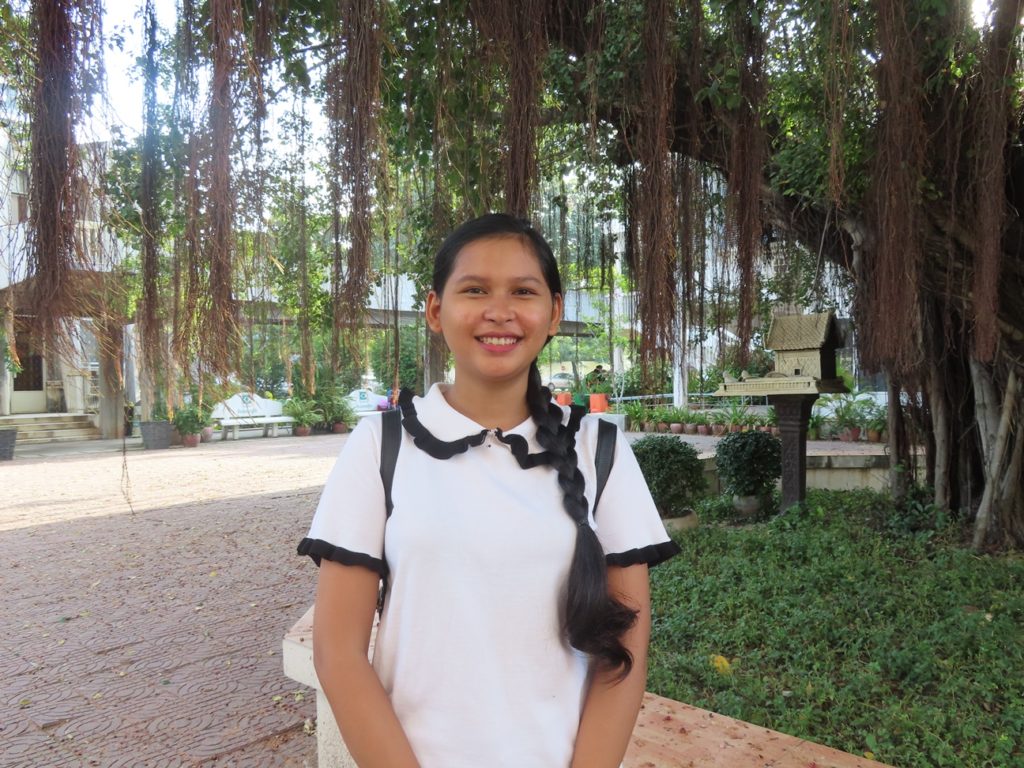 girl with long braid smiling at camera