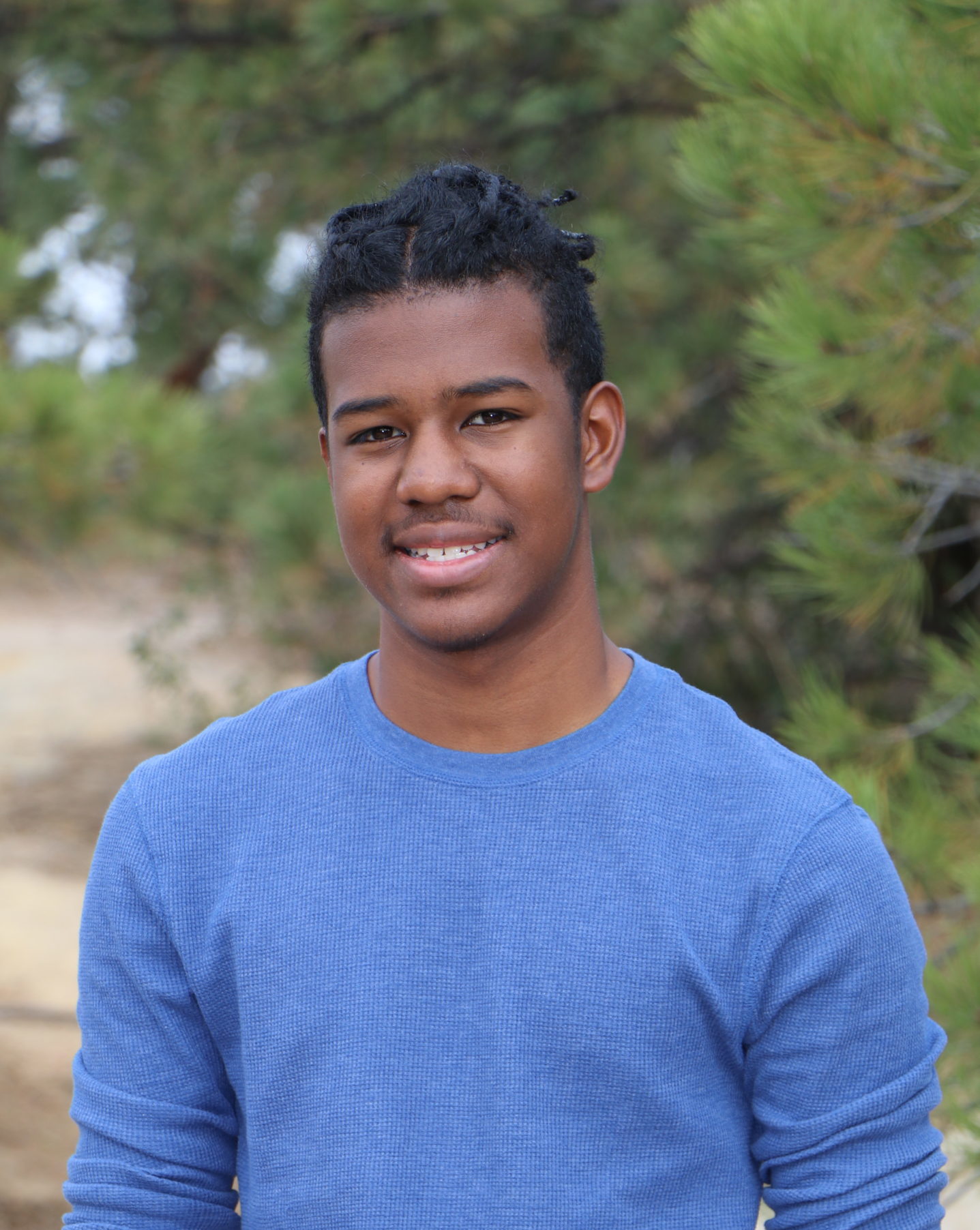 smiling man wearing blue shirt with sleeves rolled up