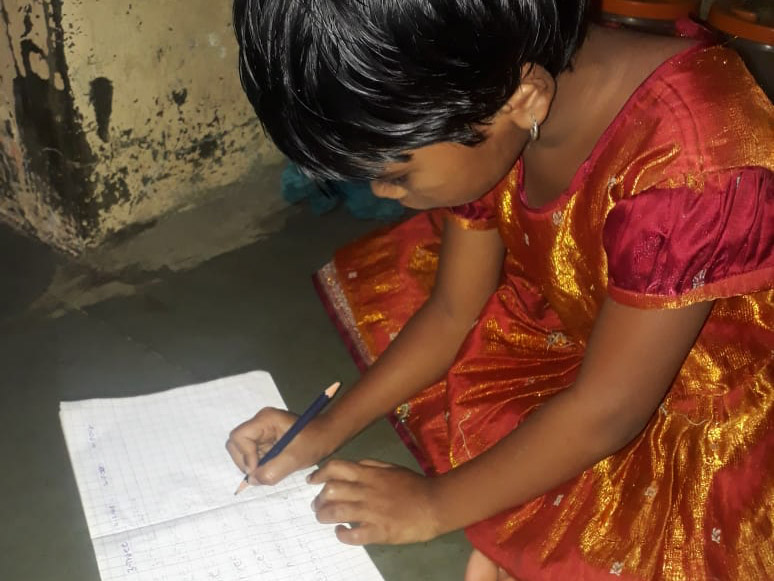 girl in red dress writing in a notebook