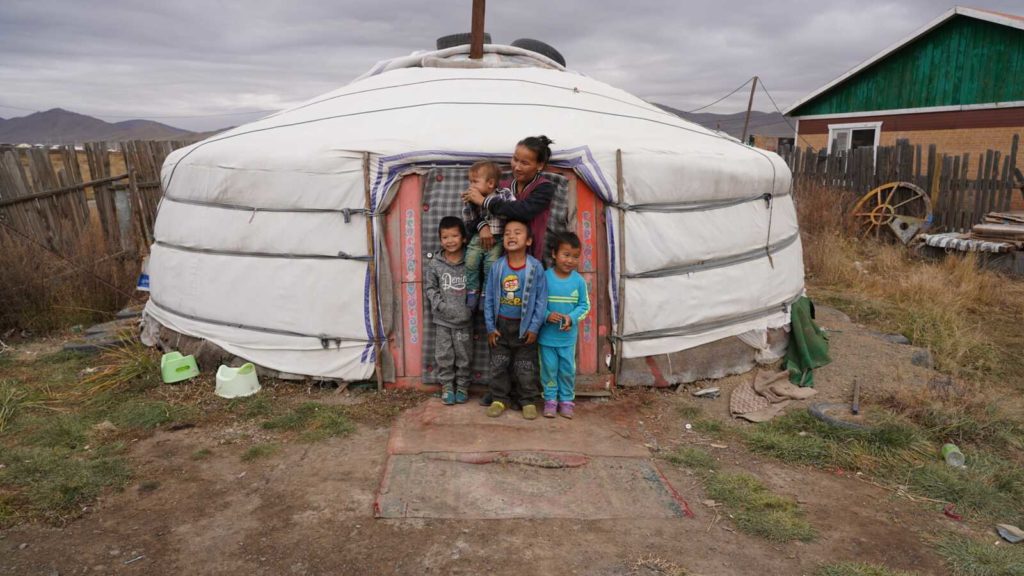 family of five standing outside of ger home