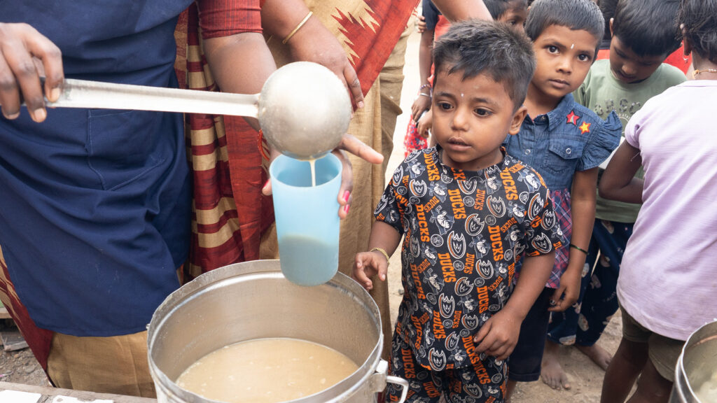 Little boy being served a food/drink/nourishment
