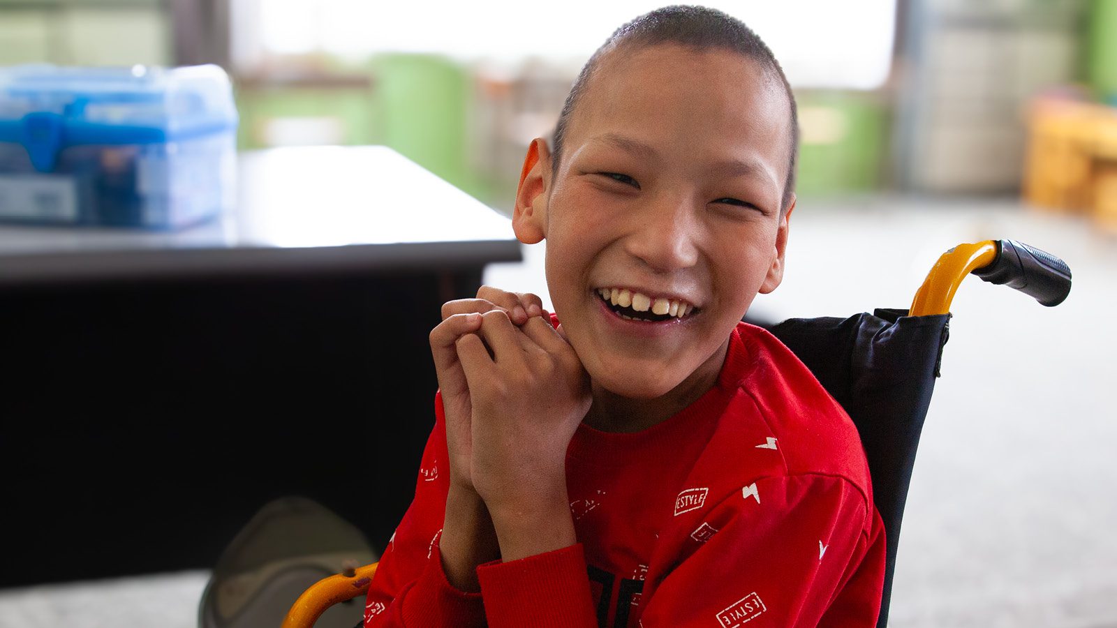 Happy, smiling boy in a wheelchair at school supported by the Molly Holt Fund