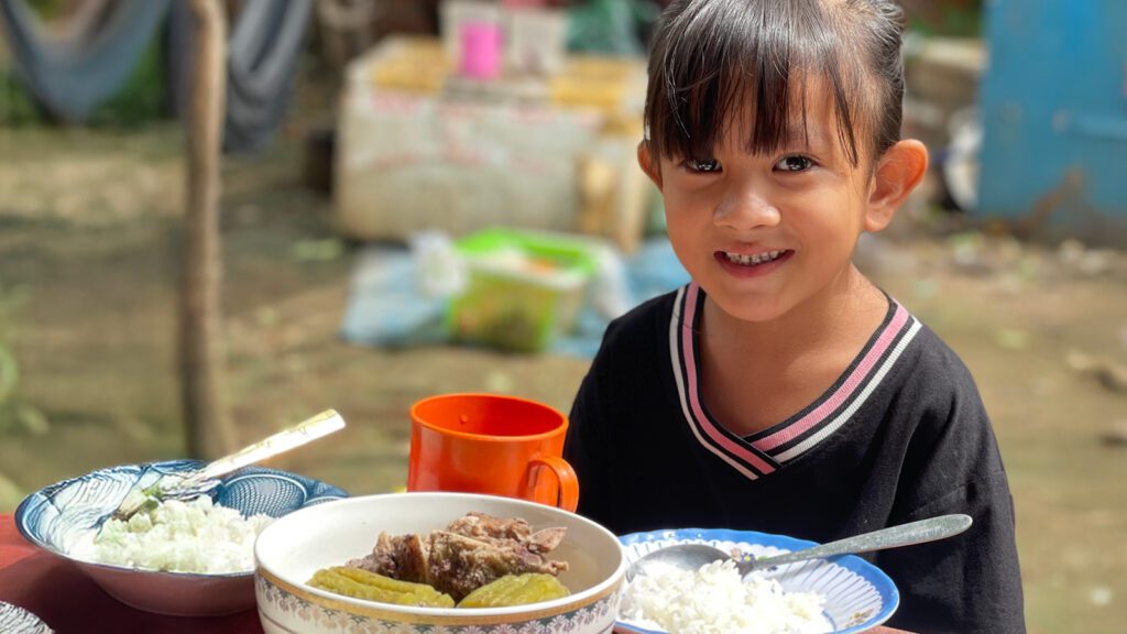 Adorable little girl eating a hearty meal