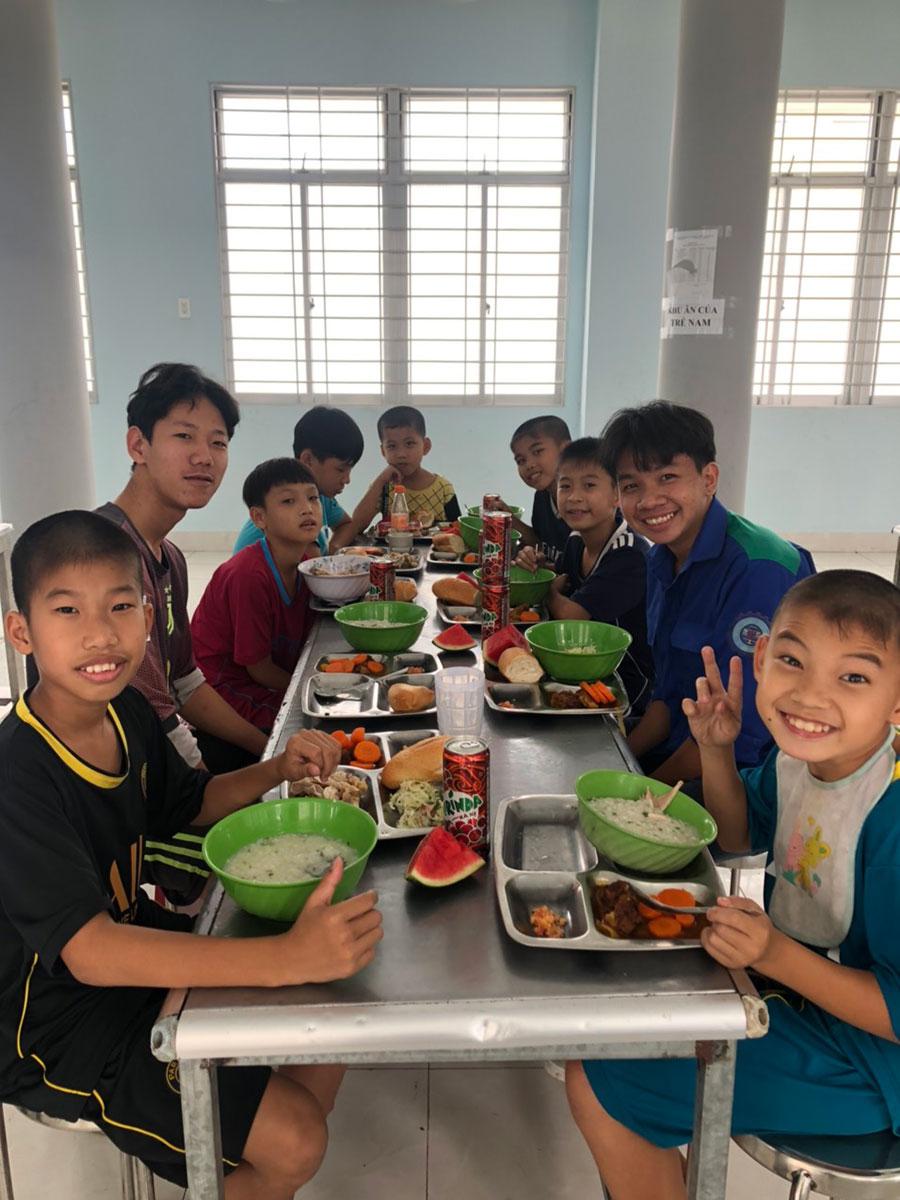 group of smiling boys sitting around a table