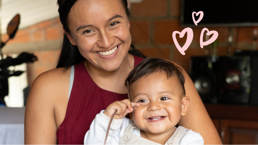 Mother holding baby, smiling