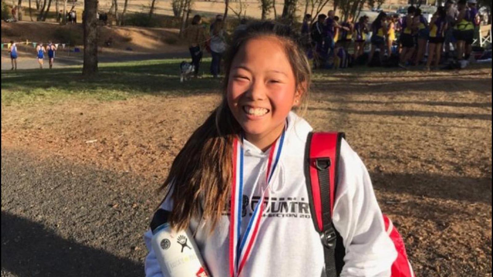adoptee with thalassemia smiling with a medal around her neck