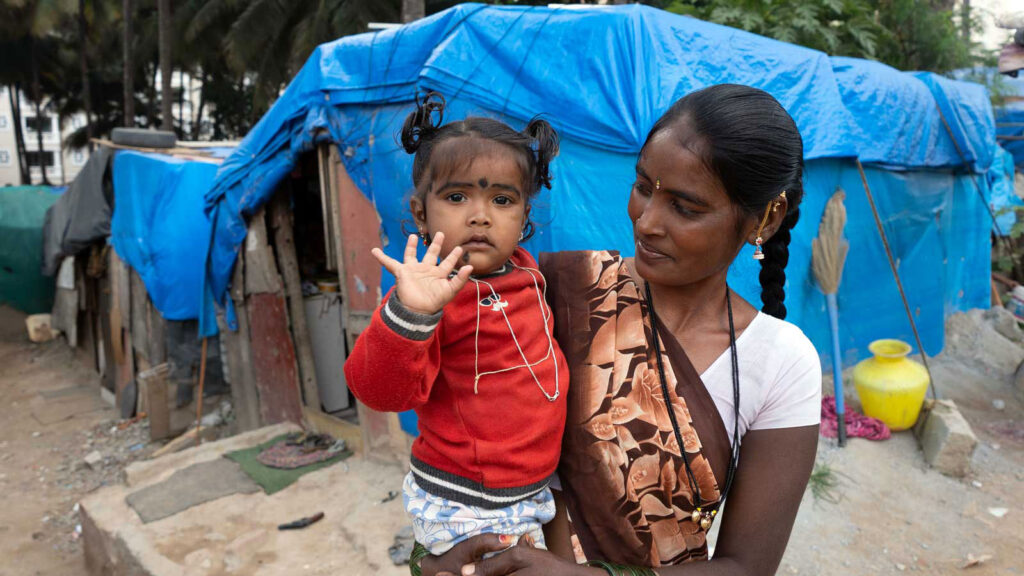 Mom holding her daughter in a slum community in India