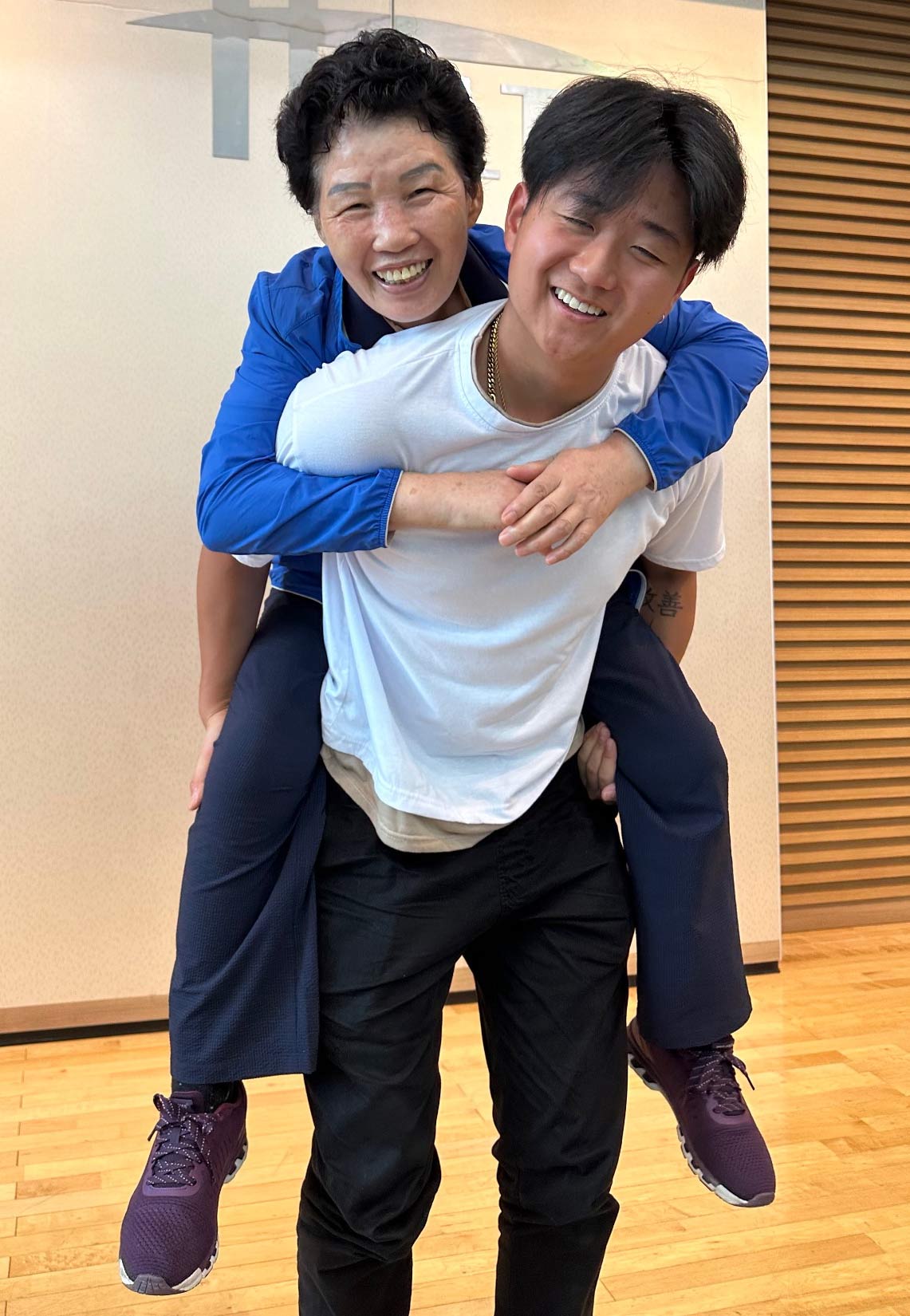 Korean adoptee carrying his foster mom on his back