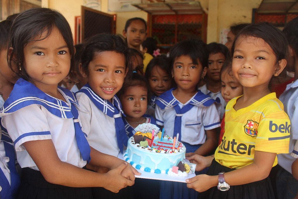 Children in Cambodia hold a birthday cake to celebrate International Children's Day.