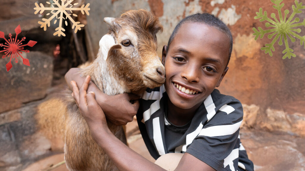 Young boy in Ethiopia hugging his goat