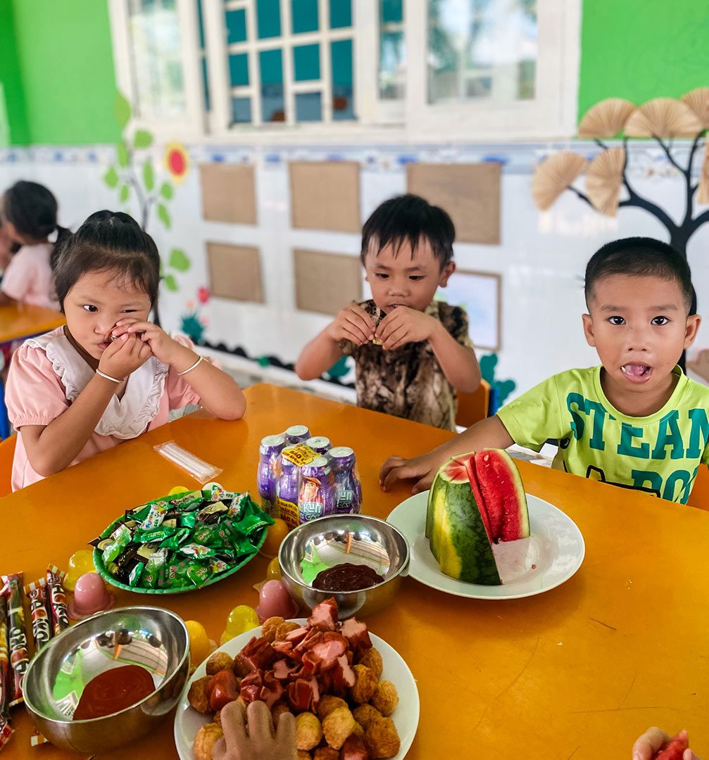 Children at a daycare in Vietnam eat snacks