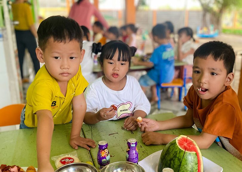 Children at a daycare in Vietnam eat snacks