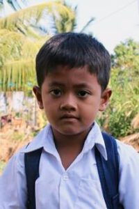 Piseth, a sponsored child from Cambodia, wears his school uniform 