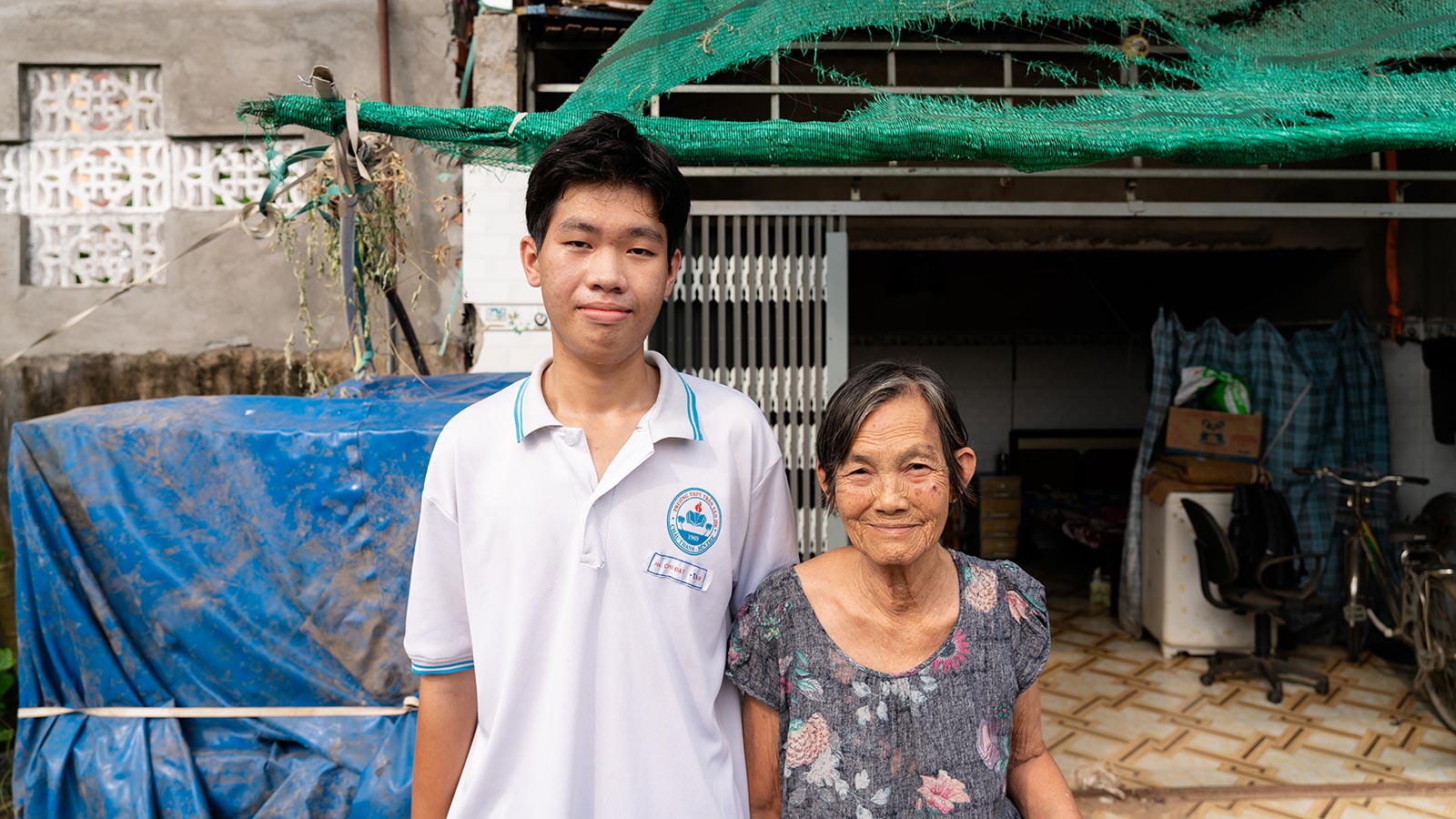 close up of a grandmother and grandson smiling with a view looking into their home behind them