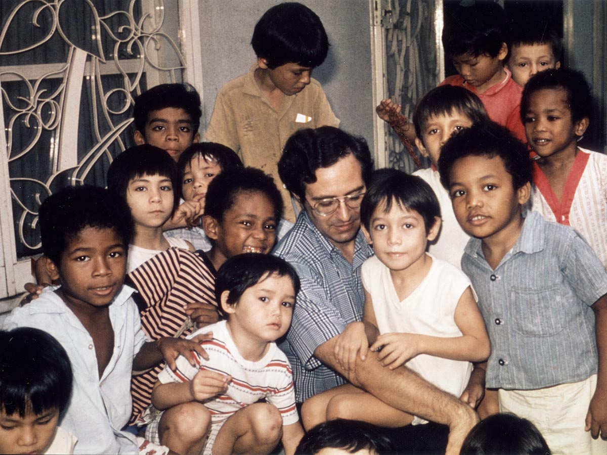 a Holt staff member in Saigon poses for a photo with children before evacuation