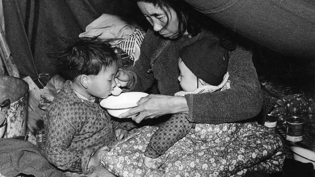 a refugee from Da Nang feeds her child in Saigon, Vietnam