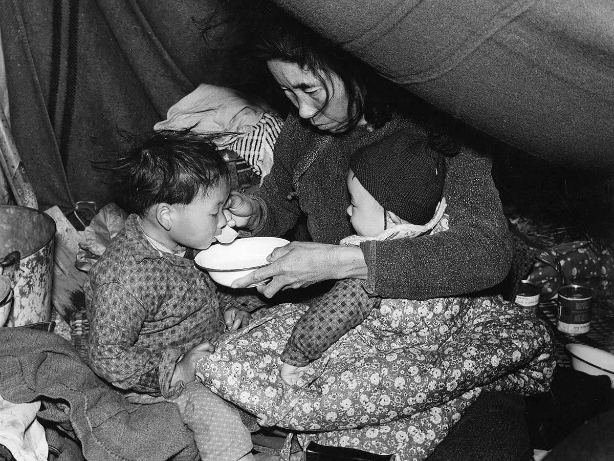 a refugee from Da Nang feeds her child in Saigon, Vietnam