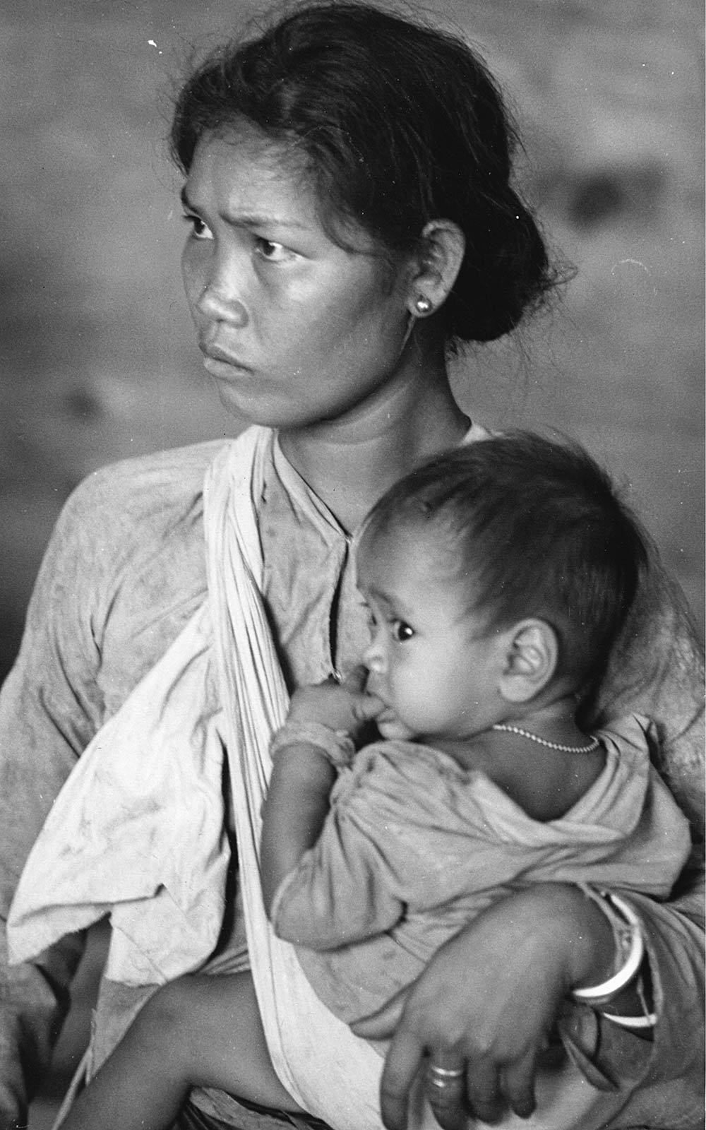 a refugee mother holds her baby in Saigon after fleeing south of Da Nang