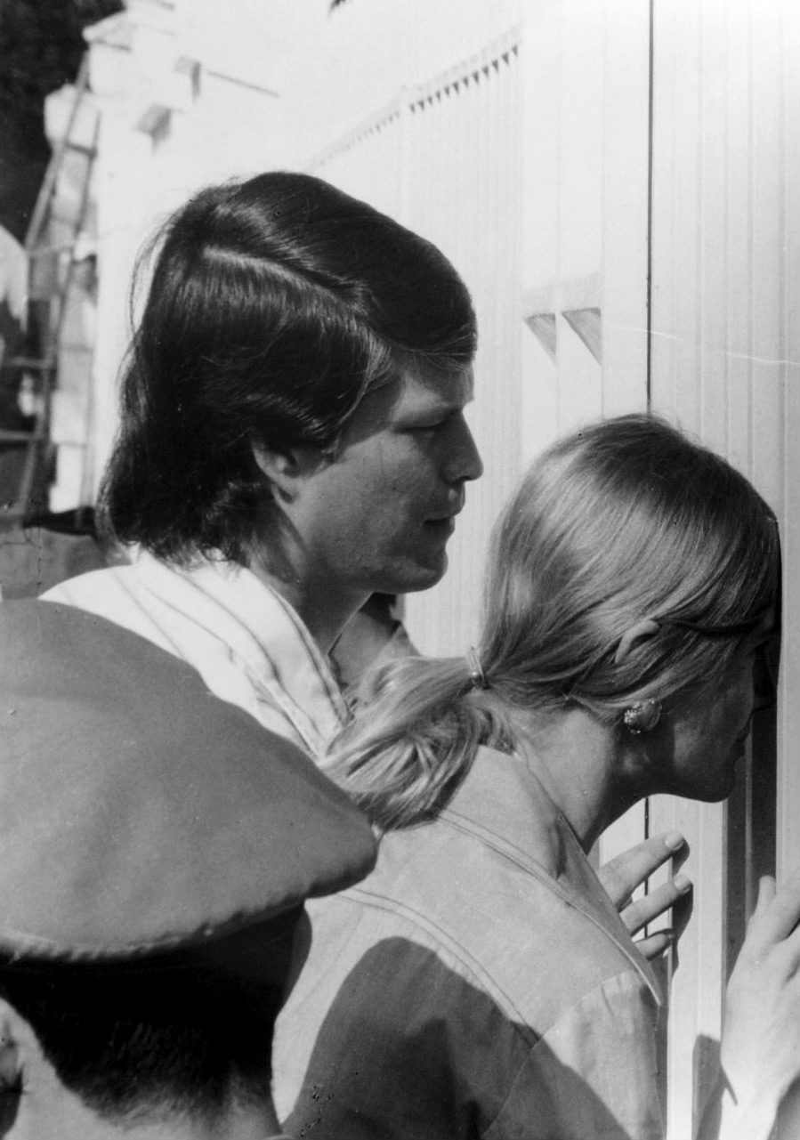 a man peers through the gates of the U.S. Embassy in Saigon, Vietnam 1975.