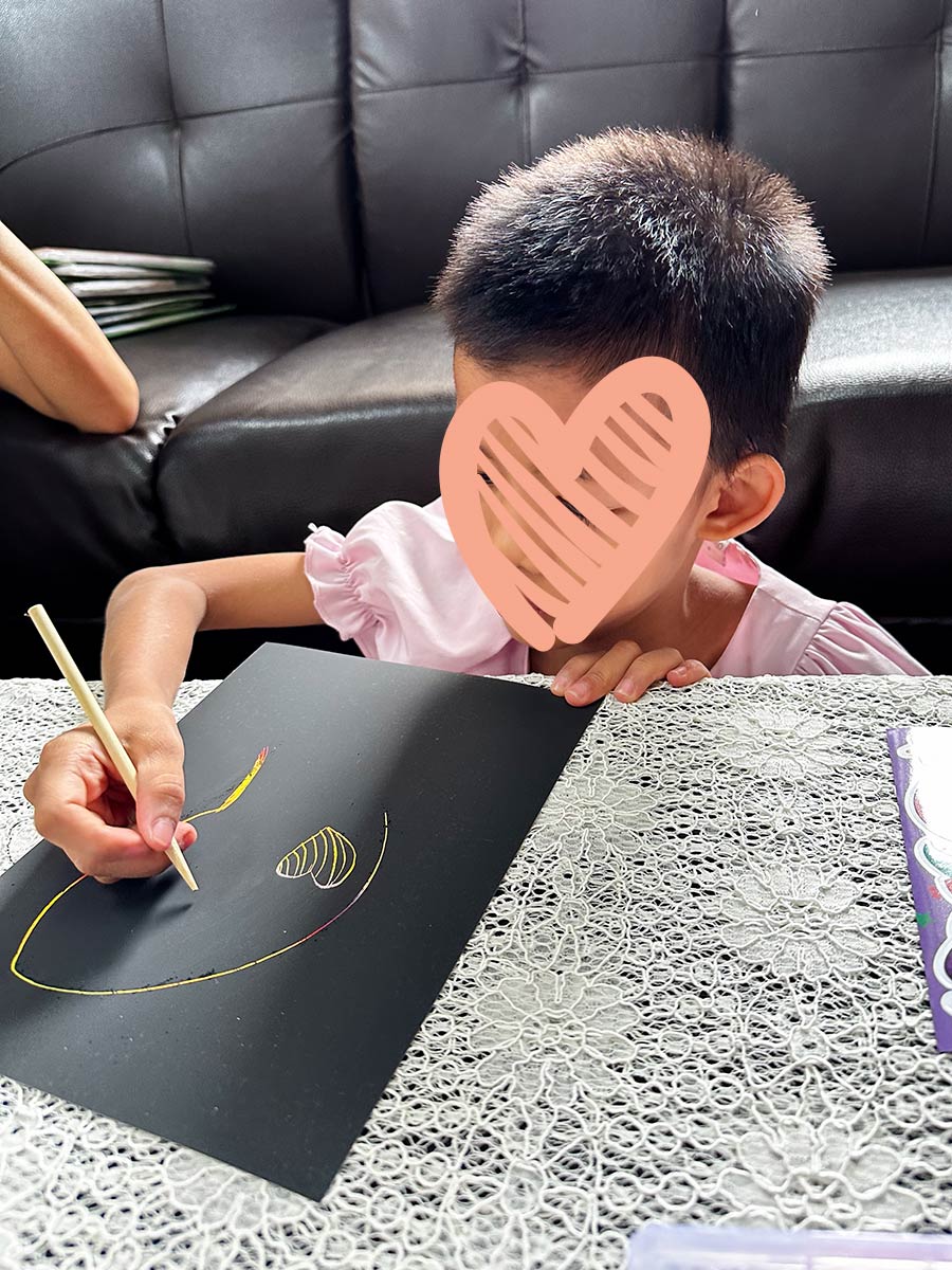 A waiting child spends time on her art project. She needs an adoptive family.