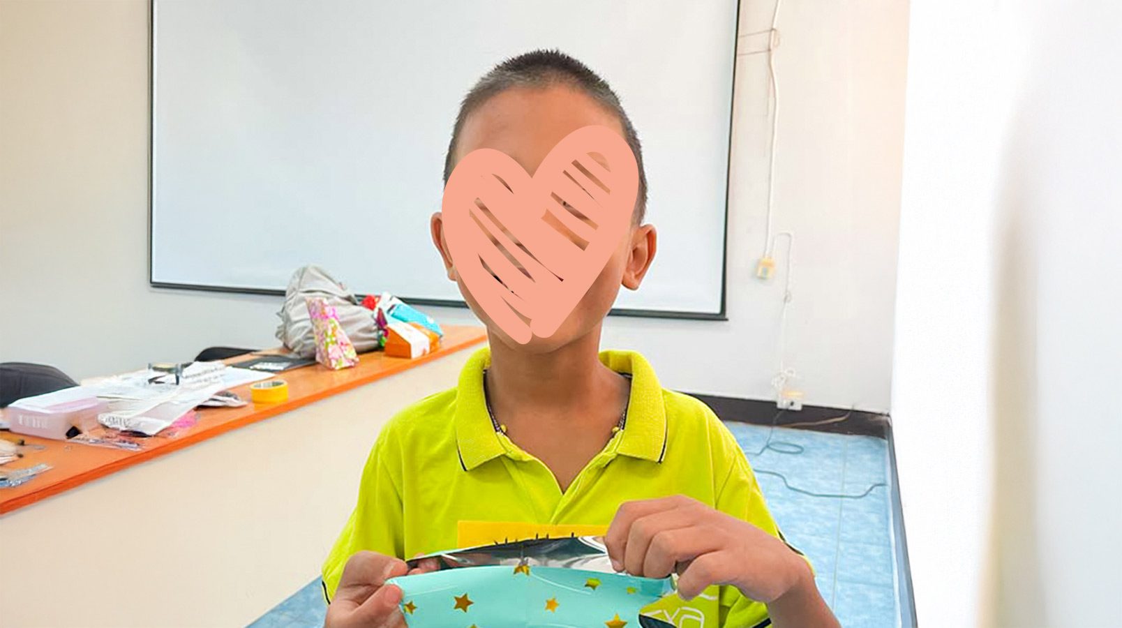 A child named shane needs a family. He smiles with a heart over his face, ready for adoption