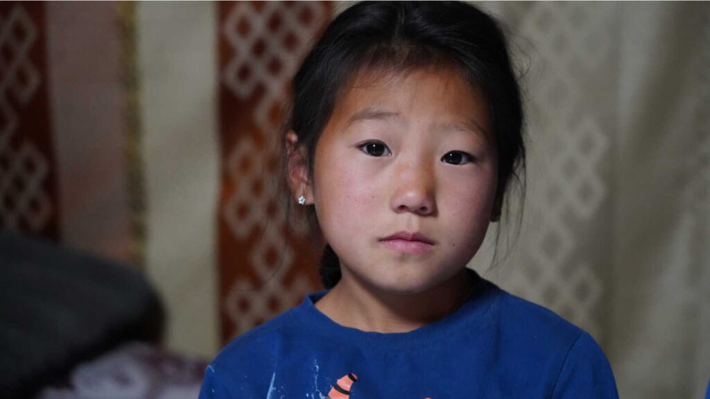 little girl looking at the camera, sad