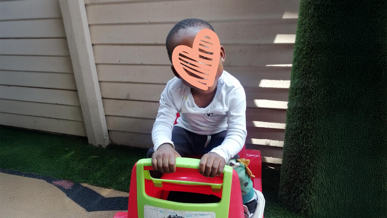 a waiting child sits on a toy truck