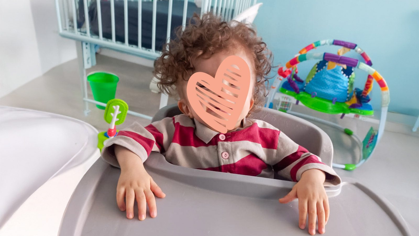 A waiting child in need of an adoptive family sits in a high chair. AJ needs a family.