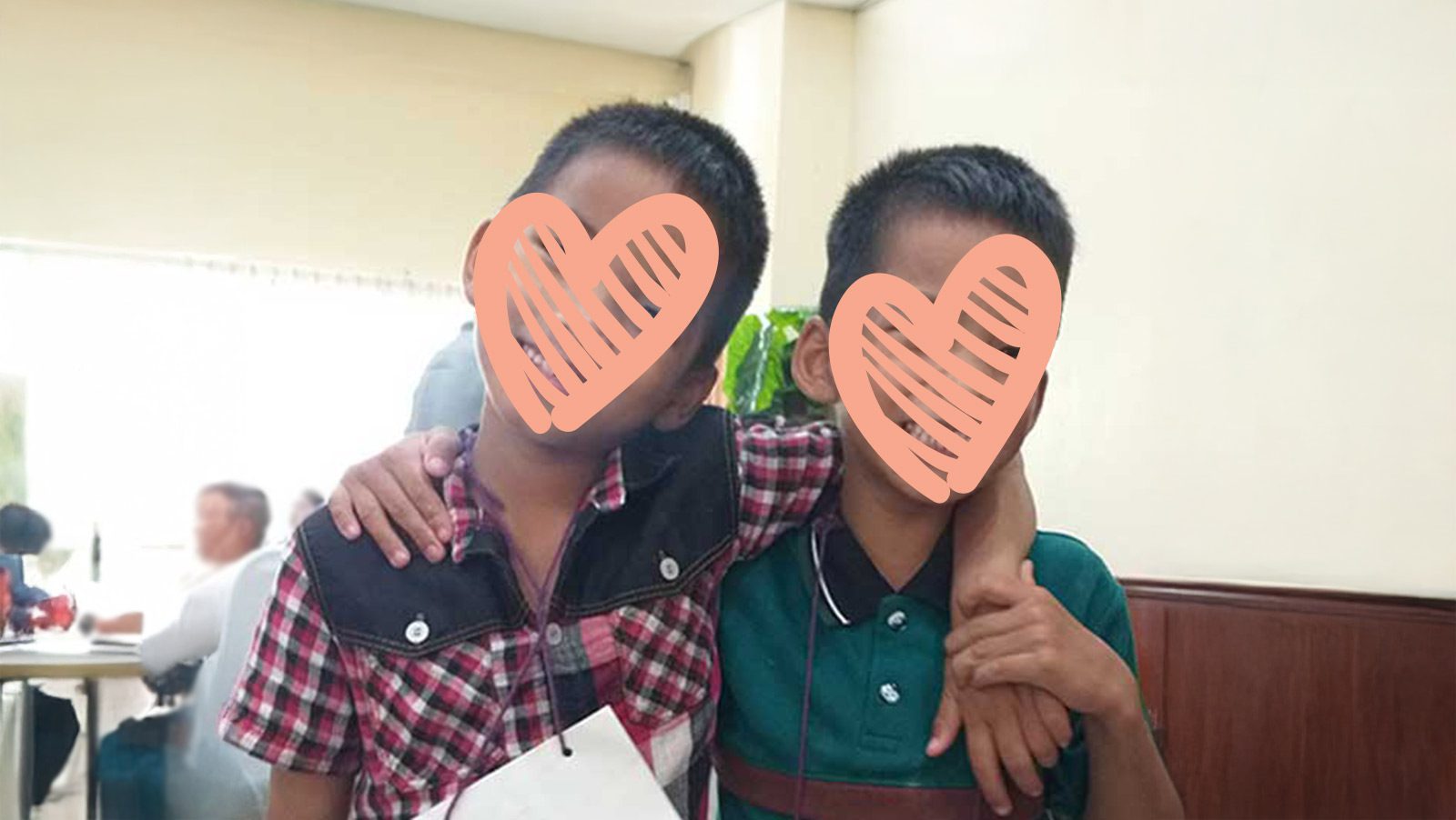 two twin boys embrace for a photo and are waiting for adoption