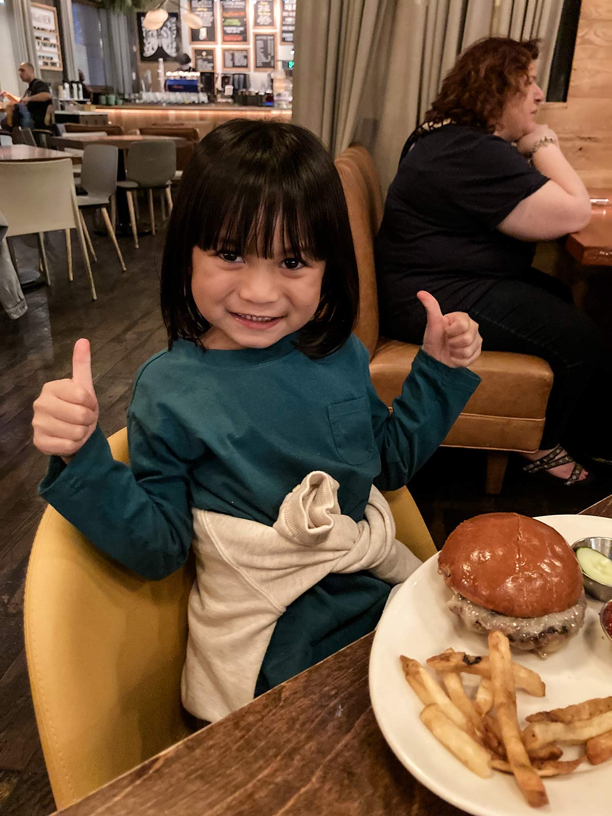an adopted child smiles with her dinner
