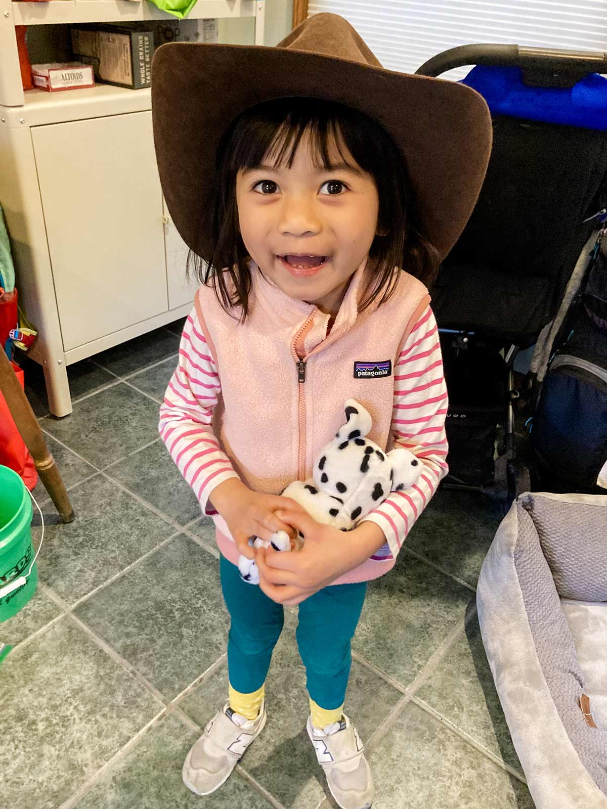 an adopted child holds a stuffed animal and smiles