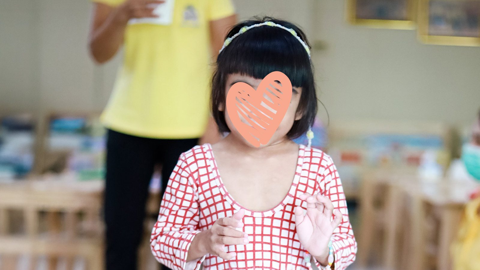 A waiting child in need of an adoptive family stands in a little dress. Winnie needs a family.