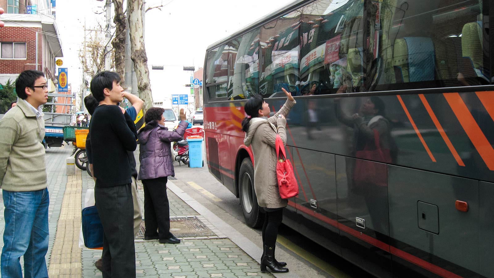 a foster mother waves goodbye to the foster child she cared for in Korea