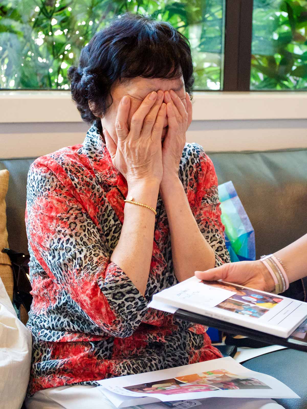 A foster mother looks at a photo album of a child she cared for.