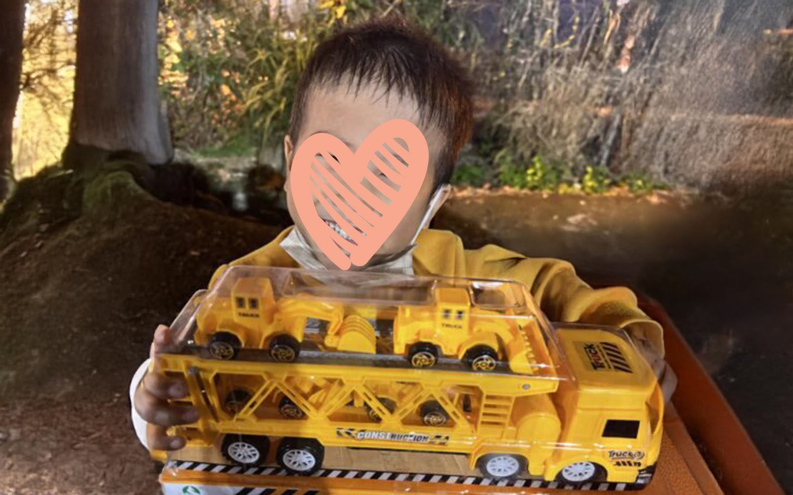 A waiting child holds a toy truck