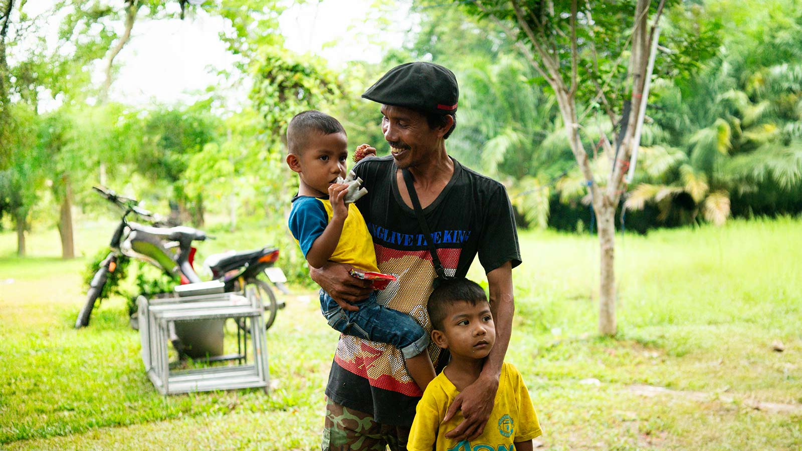 A father in Thailand cares for his children.