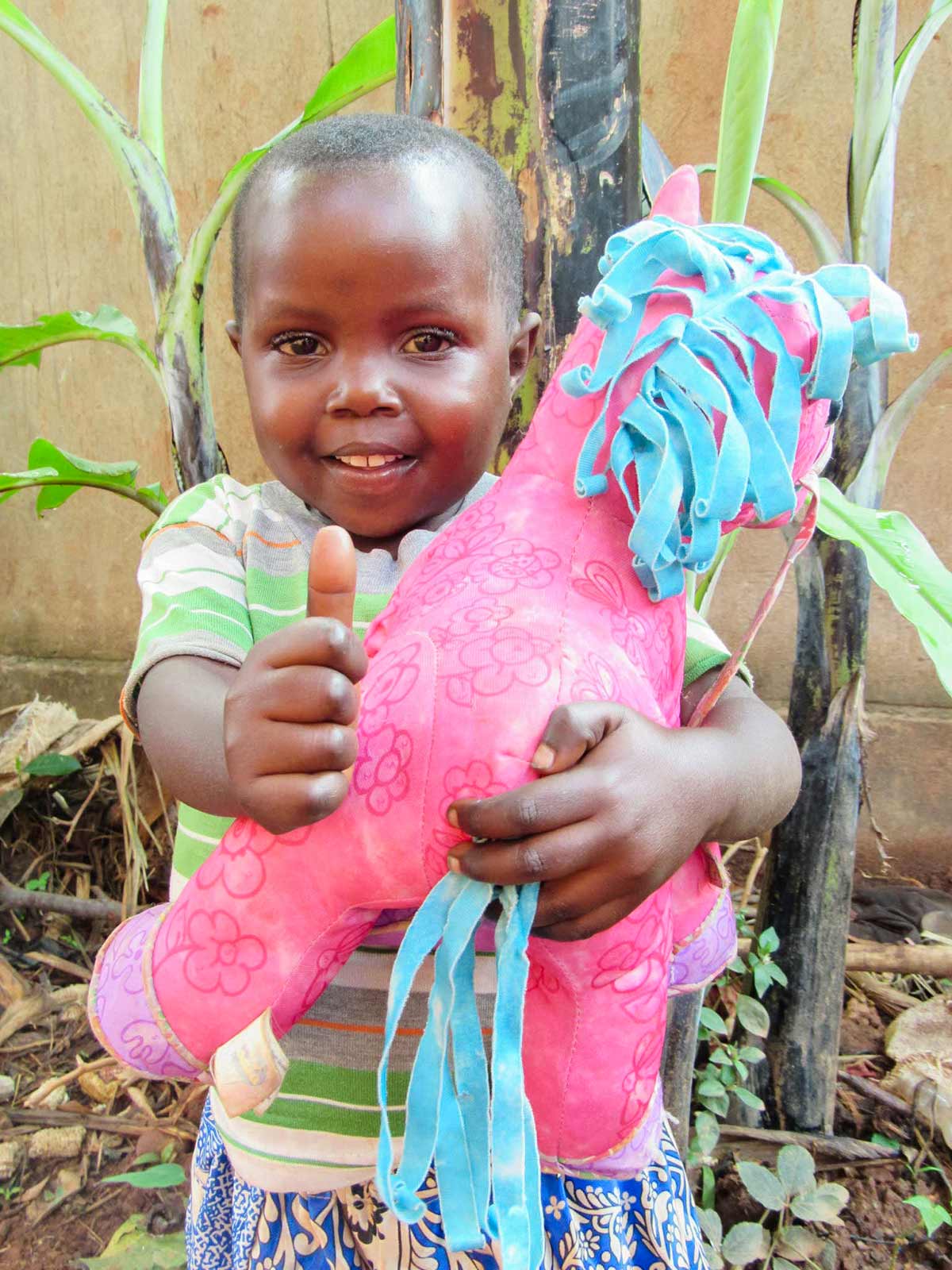 a child who is parasite-free in uganda smiles and gives a thumbs up