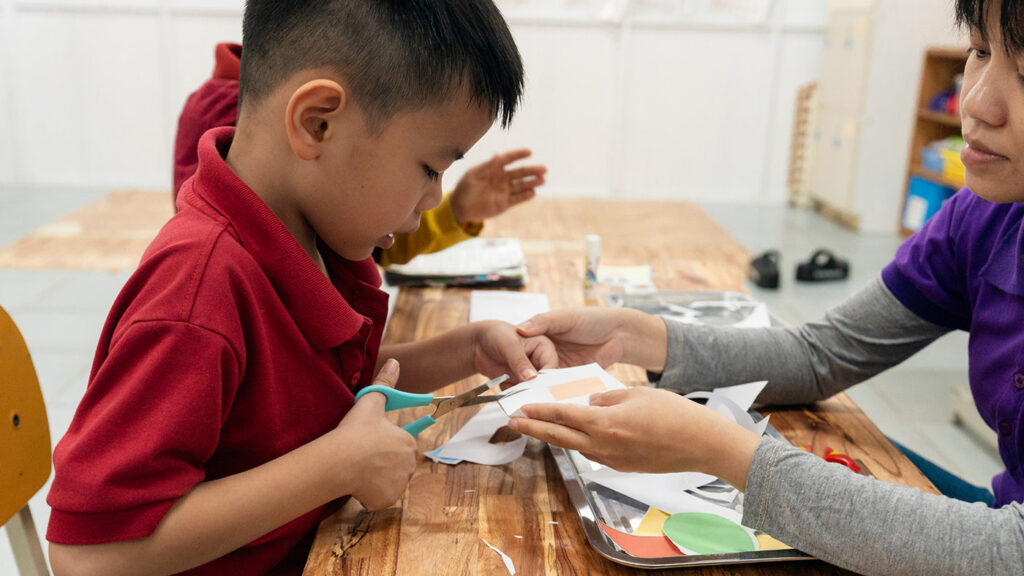 A child learns to cut with scissors